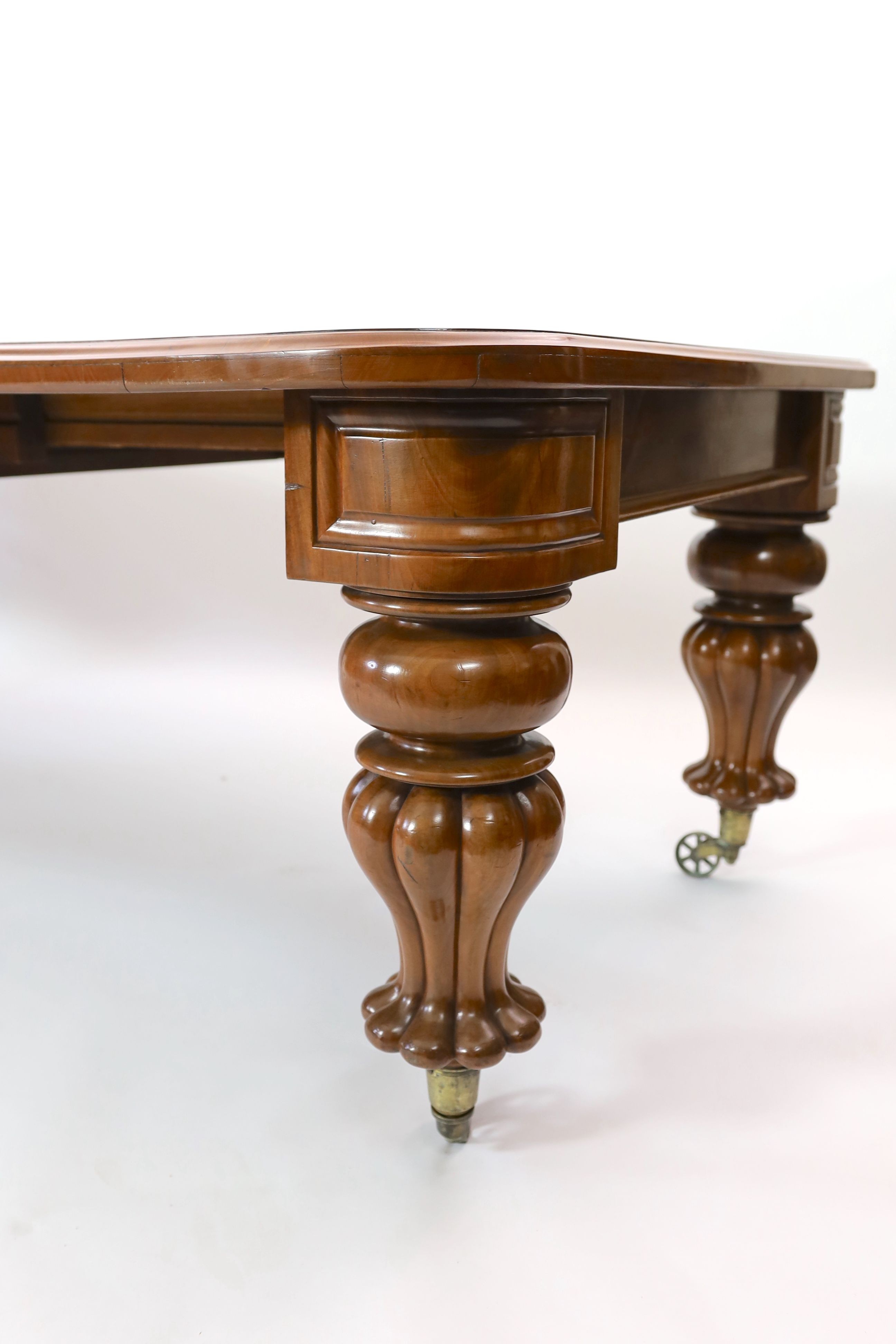 A mid Victorian mahogany extending dining table, on fluted baluster legs and spoked brass castors, 355cm extended, three spare leaves, width 118cm height 73cm